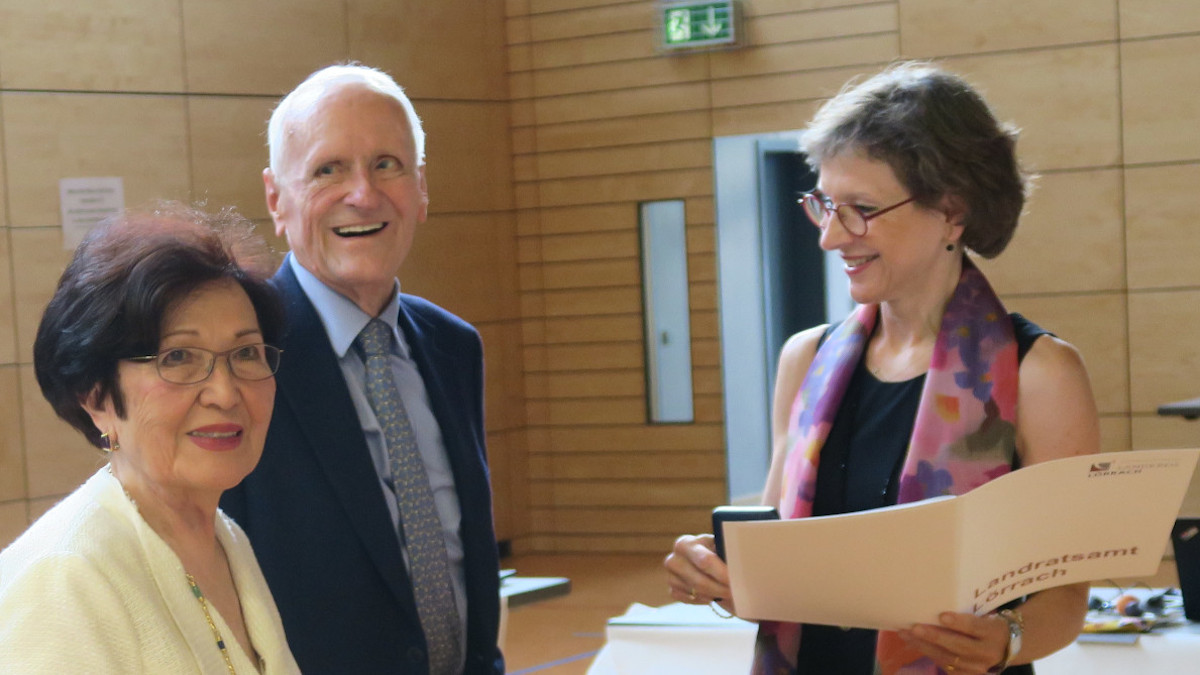 Marion Dammann presents Ayhan and Dr Karl Busch with the certificate and the Gold Medal.