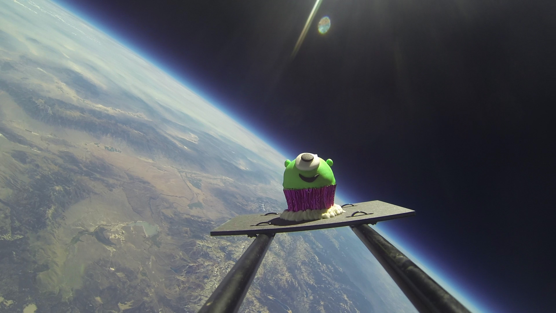 Grüner Cupcake bestaunt blauen Planeten. Grüner Cupcake bestaunt blauen Planeten.