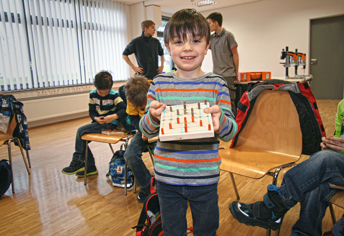Stolz präsentieren die Kinder das selbst gemachte FEIN Mühlespiel