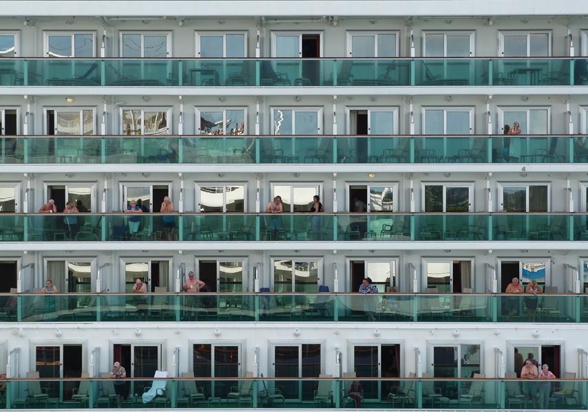 Motiv: Ein Kreuzfahrtschiff. Menschen auf den Balkonen, gemeinsam und doch voneinander getrennt.