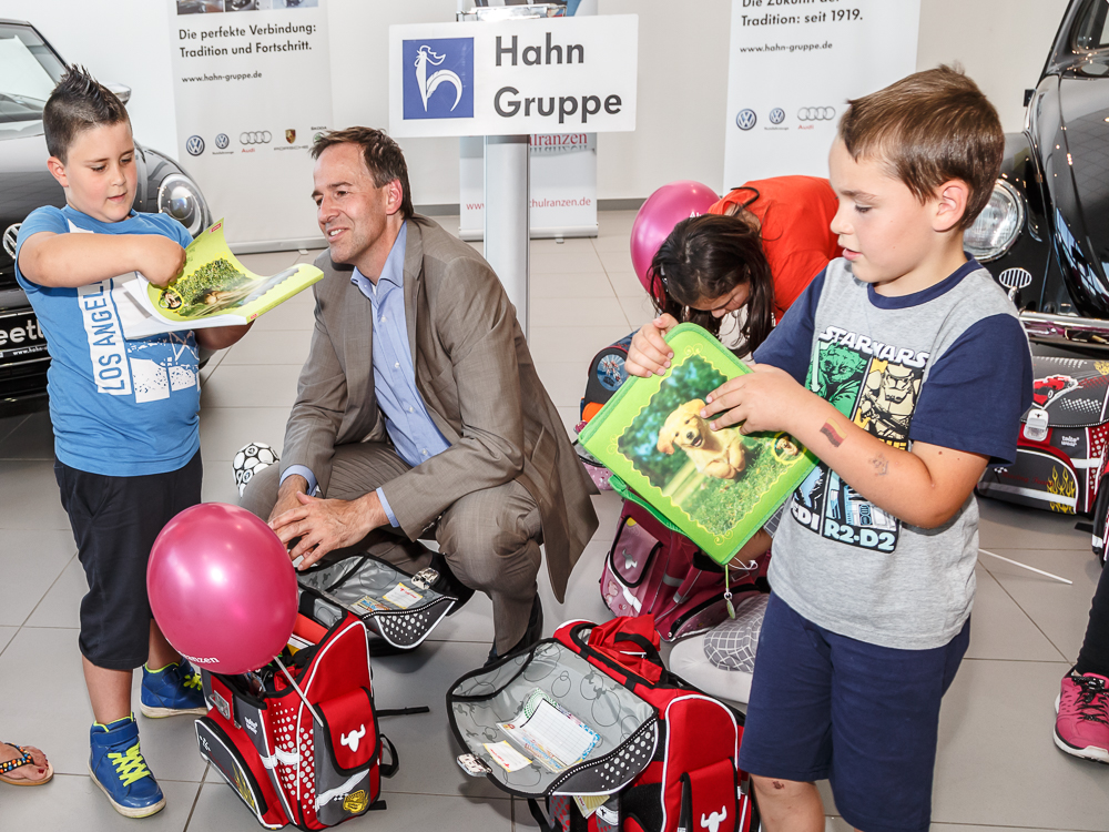 Claus Reuter, Vorstand der HUMANUS-Stiftung zeigt den Kindern ihre neuen Schulranzen