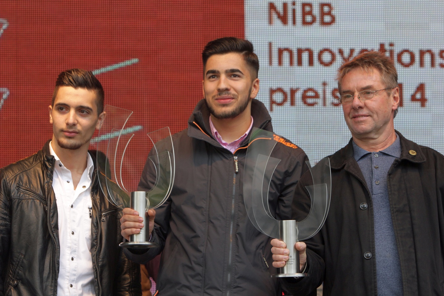 Ibrahim Yilmaz, Luca Souag und Pfarrer Willi Oberbeck nehmen den NiBB-Innovationspokal entgegen. Ibrahim Yilmaz, Luca Souag und Pfarrer Willi Oberbeck nehmen den NiBB-Innovationspokal entgegen.