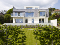 Designhaus Griffen mit einer Kombination aus traditionellen Holzschindeln und schlichter Putzfassade Designhaus Griffen mit einer Kombination aus traditionellen Holzschindeln und schlichter Putzfassade