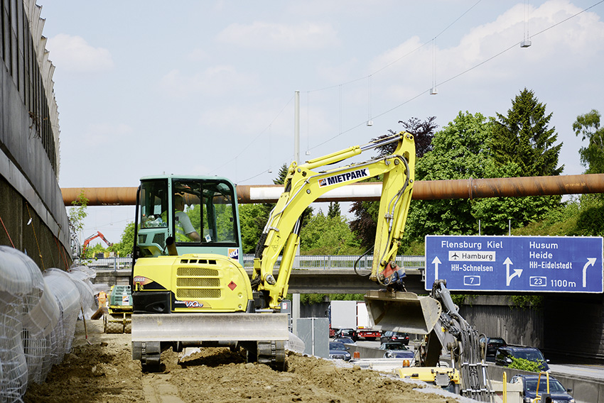 Ein Bagger von HKL hilft beim Aufbau eines etwa vier Meter hohen Podestes am Fahrbahnrand der A7. Ein Bagger von HKL hilft beim Aufbau eines etwa vier Meter hohen Podestes am Fahrbahnrand der A7.