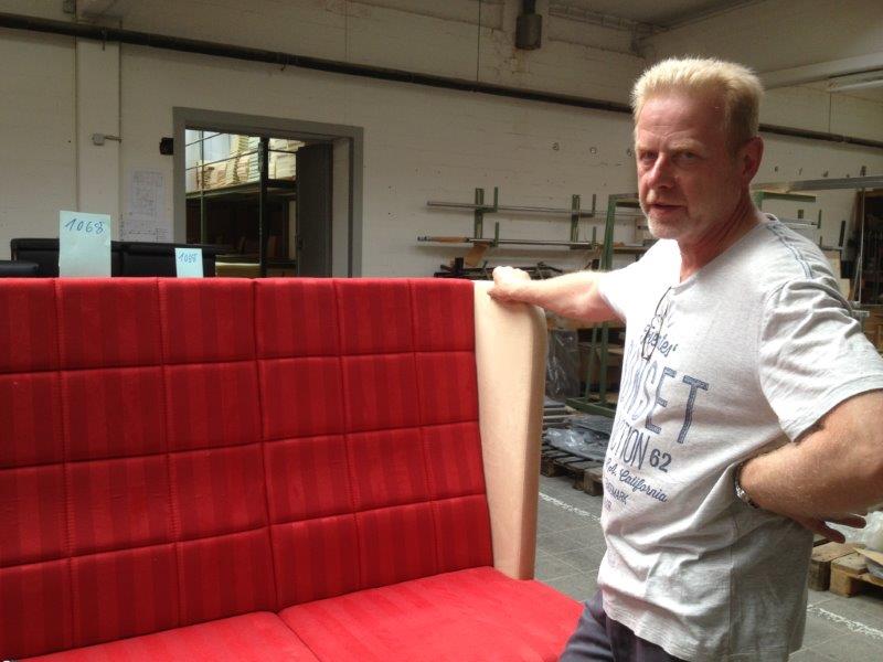 Uli Aulke von der Stuhlfabrik Schnieder an einem Ohrensofa mit gestepptem Rücken