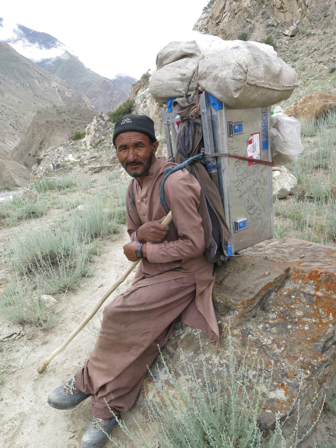 Sherpas tragen die Ausrüstung der Huberbuam in ZARGES-Kisten durch das unwegsame Gelände in Pakistan
