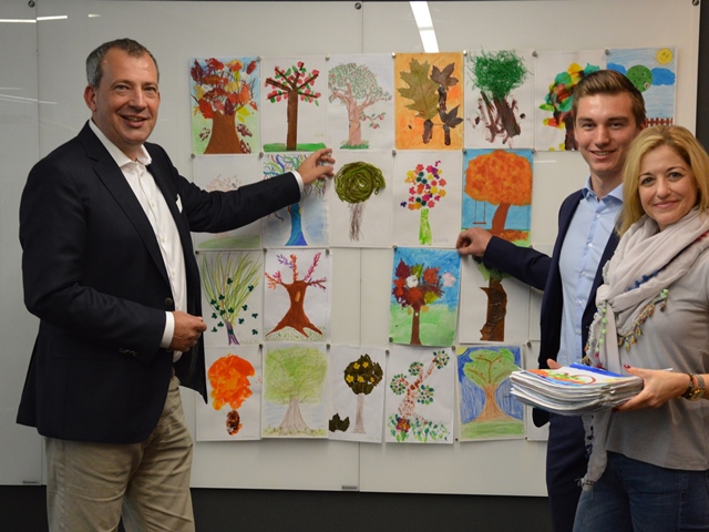Sparda-Bank-Vorstandschef Stefan Schindler (links) und zwei Mitarbeiter mit einer Auswahl der Bilder