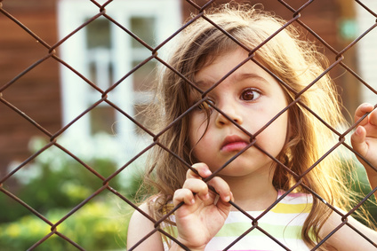 Mutistisches Mädchen schaut sehnsüchtig spielenden Kindern zu Mutistisches Mädchen schaut sehnsüchtig spielenden Kindern zu
