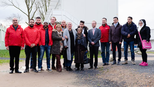 Jürgen Hoffmeister, Geschäftsführer des DRK Kiel, sein Team und geflüchtete Familien © Frank Molter Jürgen Hoffmeister, Geschäftsführer des DRK Kiel, sein Team und geflüchtete Familien © Frank Molter
