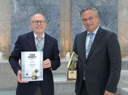 Jochen Wenzel (re.) und Peter Schmieder mit dem „Stein im Brett“-Award. (Foto: Knauf)