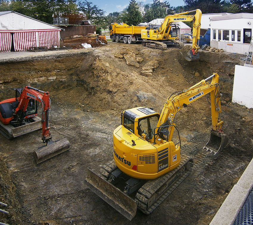 Mehrere Raupenbagger aus dem HKL MIETPARK heben das Fundament für eine Tiefgarage aus.