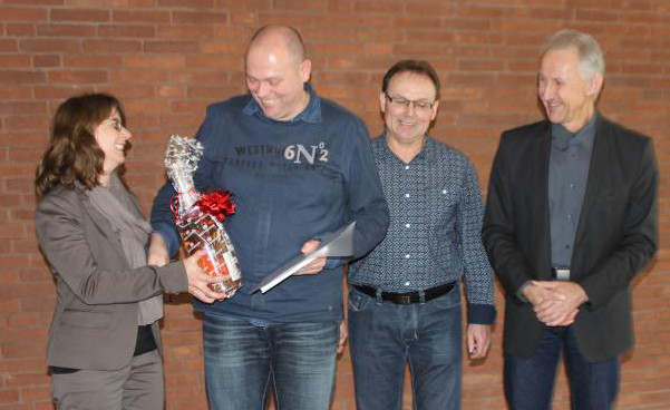 Andrea Bauer (REFA Hessen)überreicht dem Prüfungsbesten Ansgar Kohl eine Flasche Champagner.