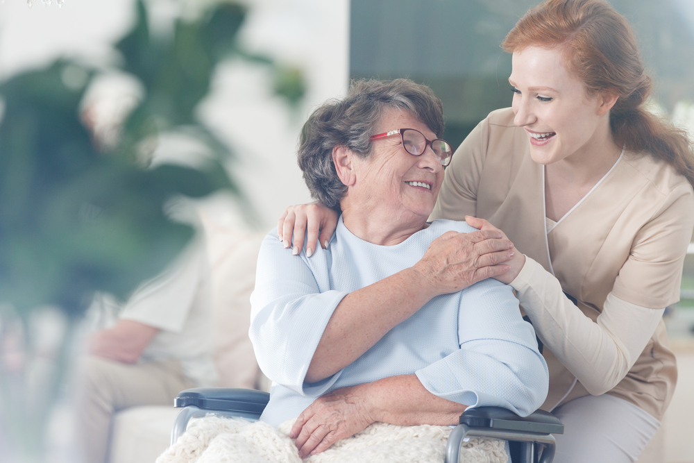 Senioren-Assistentin im Dienst an einer Seniorin