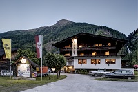 Frontansicht Zollwirt bei Dämmerung mit Bergpanorama (Alpengasthof Zollwirt)