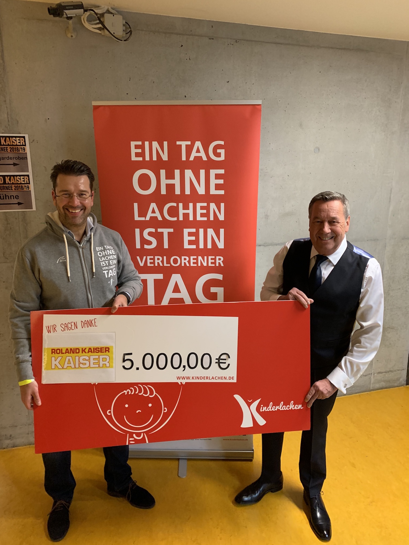 Kinderlachen-Mitgründer Marc Peine (l.) nahm einen Spendencheck von Roland Kaiser entgegen. (Bildque Kinderlachen-Mitgründer Marc Peine (l.) nahm einen Spendencheck von Roland Kaiser entgegen. (Bildque