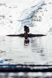 Frau relaxt im Infinity Pool mit Blick auf das traumhafte Zürser Bergpanorama (c) P. Langwallner (Ho