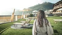 Frau entspannt in der Parkanlage (Alpin Panorama Hotel Hubertus)