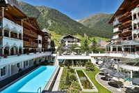Blick in den Innenhof mit Bergpanorama und Pool im Sommer (Trofana Royal)