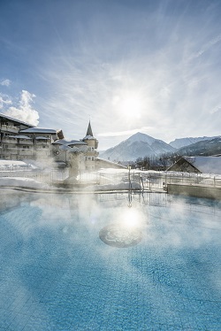 Ausblick vom Outdoor Pool auf das Hotel im Winter (Posthotel Achenkirch)