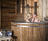 Pärchen im Außenwhirlpool des Chalets (Hüttenhof - Wellnesshotel und Luxus-Bergchalets) Pärchen im Außenwhirlpool des Chalets (Hüttenhof - Wellnesshotel und Luxus-Bergchalets)