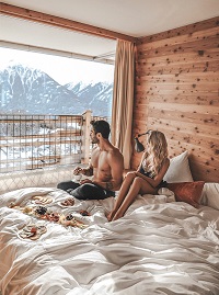 Pärchen genießt Bergblick im Bett (NIDUM) Pärchen genießt Bergblick im Bett (NIDUM)