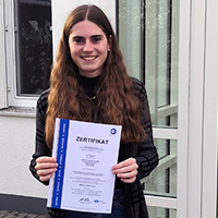 Informationssicherheitsbeauftragte Magdalena Petzenhauser hält das neue TÜV-Zertifikat in der Hand Informationssicherheitsbeauftragte Magdalena Petzenhauser hält das neue TÜV-Zertifikat in der Hand