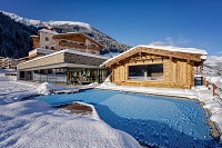 Naturschwimmteich mit Außensauna im Winter (Alpinhotel Berghaus)