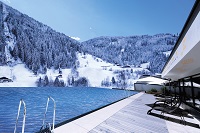 Infinity-Outdoorpool mit Bergpanorama im Winter (Das SeeMOUNT)