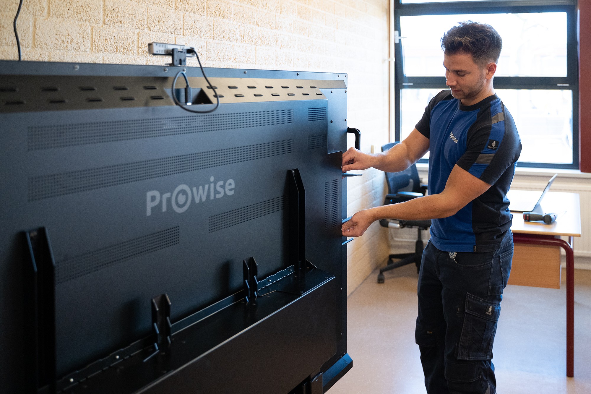 Prowise-Mitarbeiter installiert einen Touchscreen in einem Klassenraum Prowise-Mitarbeiter installiert einen Touchscreen in einem Klassenraum