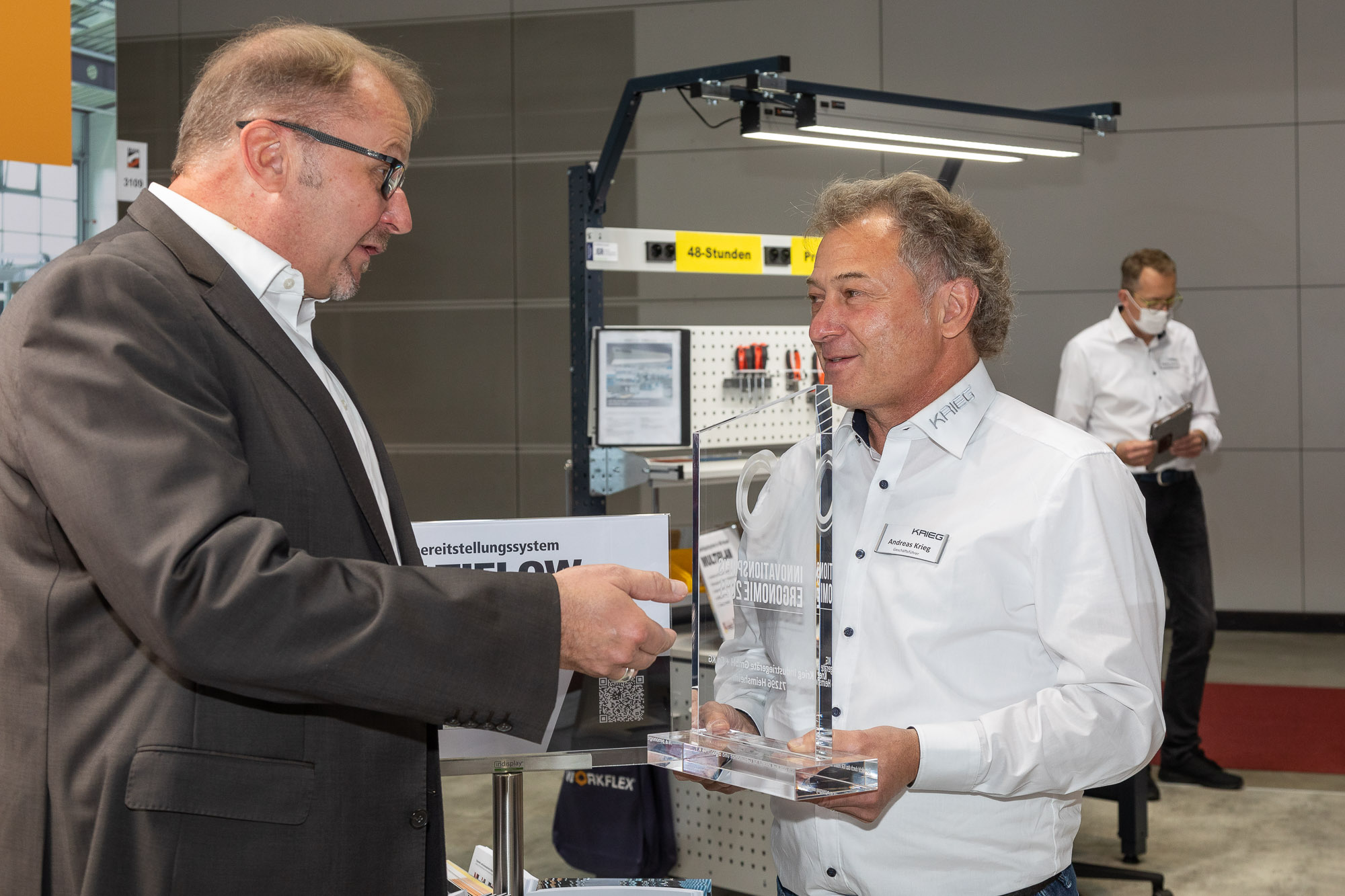 Ralf Eisele (links)überreicht den Innovationspreis Ergonomie 2021 an Andreas Krieg.