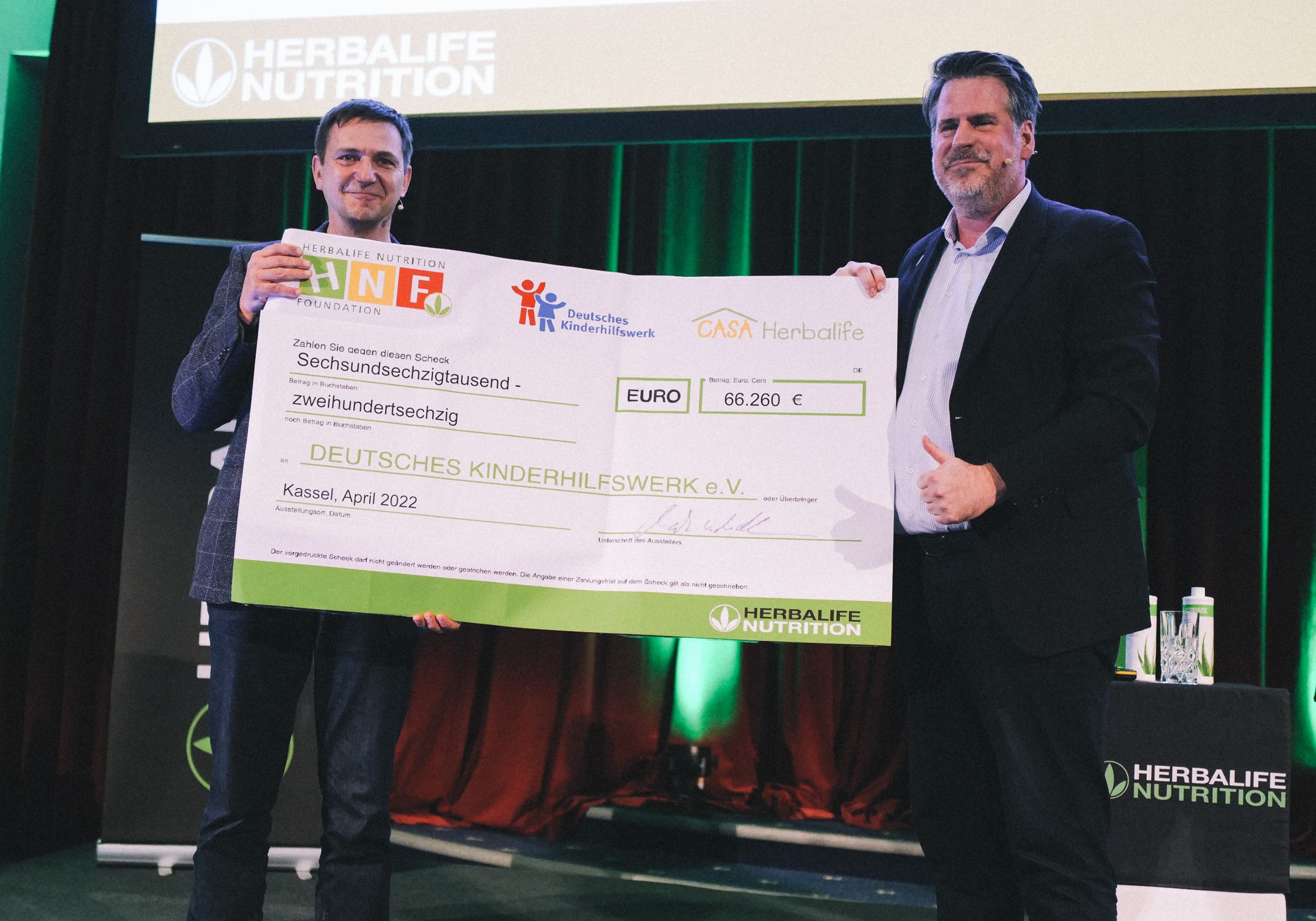 Holger Hofmann (DKHW, links) und Mark von der Meden (Herbalife Nutrition) bei der Scheckübergabe.