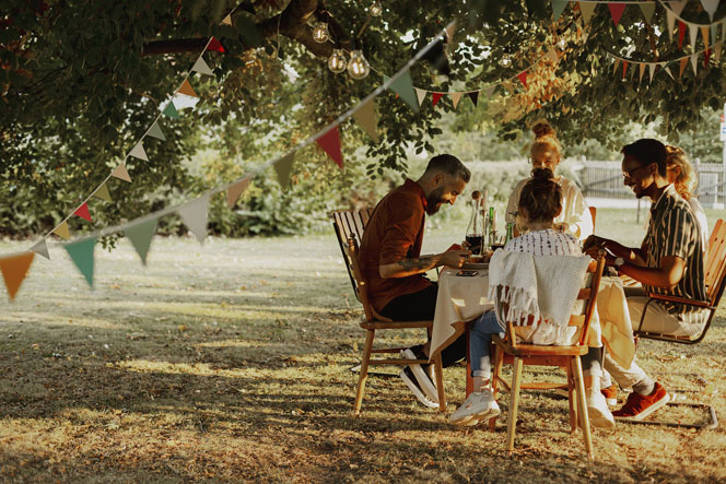 Familie und Freunde zusammen an einem Tisch im Urlaub (Bildquelle: Getty Images)