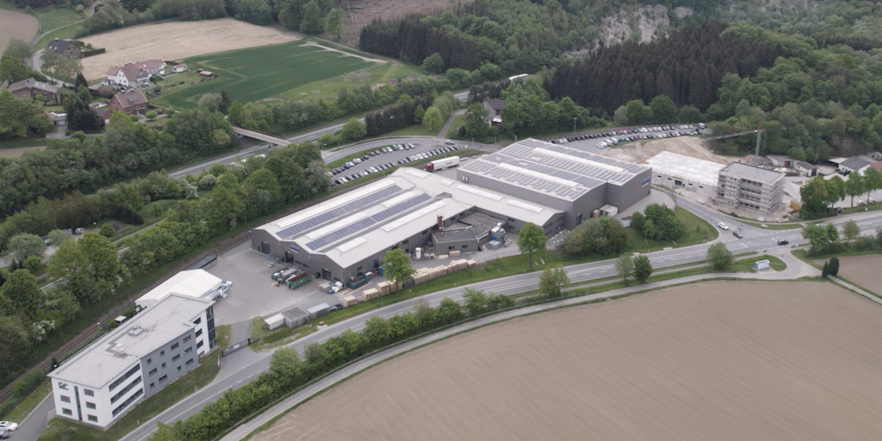 Luftbildaufnahme Firmengelände September 2022: Büro-, Produktions- und Logistikgebäude mit Neubau (Die Bildrechte liegen bei dem Verfasser der Mitteilung.)