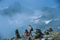 Steinmandl und Bergsteiger genießen die Aussicht Steinmandl und Bergsteiger genießen die Aussicht