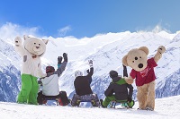 Familie hat Spaß beim Rodeln mit Maskottchen (c)Wildkogel - Arena Neukirchen & Bramberg