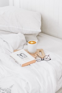 Ein gutes Buch mit Cappuchino im Bett lesen (c) unsplash (Fräulein Leni)