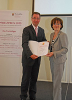 Klaus-Jürgen Philipp nimmt Urkunde von Margit Conrad entgegen. Quelle Franz Froeßl, Umweltministeriu