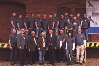 Die PFAU-Tec Geschäftsführer F. Schlüter und A. Mustermann (4. und 6. von links, 1. Reihe) mit Team. Die PFAU-Tec Geschäftsführer F. Schlüter und A. Mustermann (4. und 6. von links, 1. Reihe) mit Team.