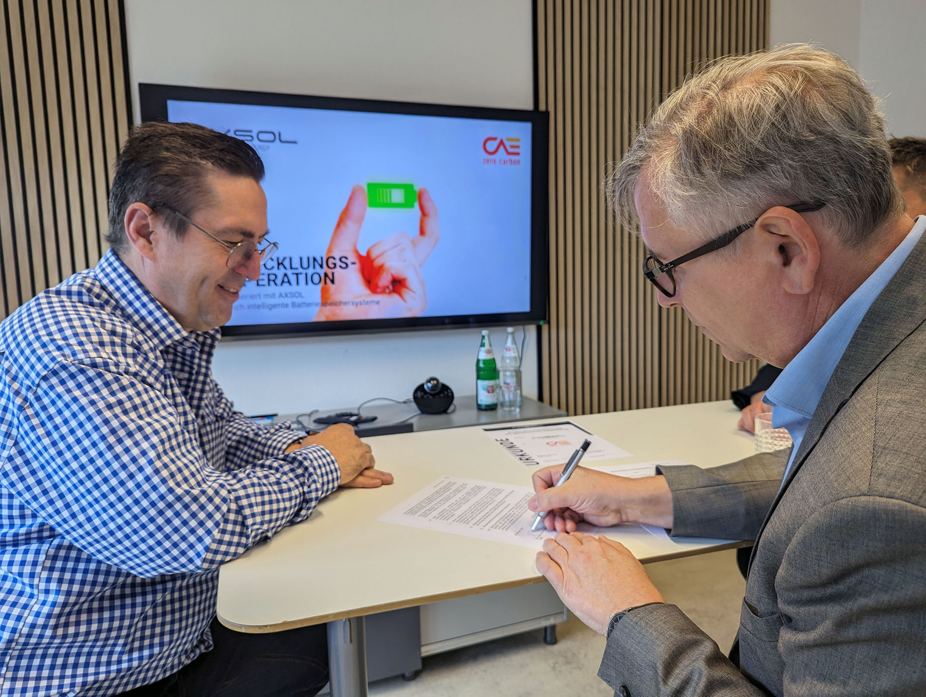 Jürgen Zinecker (AXSOL) und Dr. Hans-Peter Ebert (CAE) unterzeichnen die Entwicklungskooperation. 