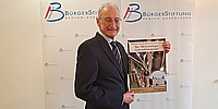 Dr. Michael Eckstein mit dem Ahrensburger Weihnachtskalender 2024 (BürgerStiftung Region Ahrensburg)