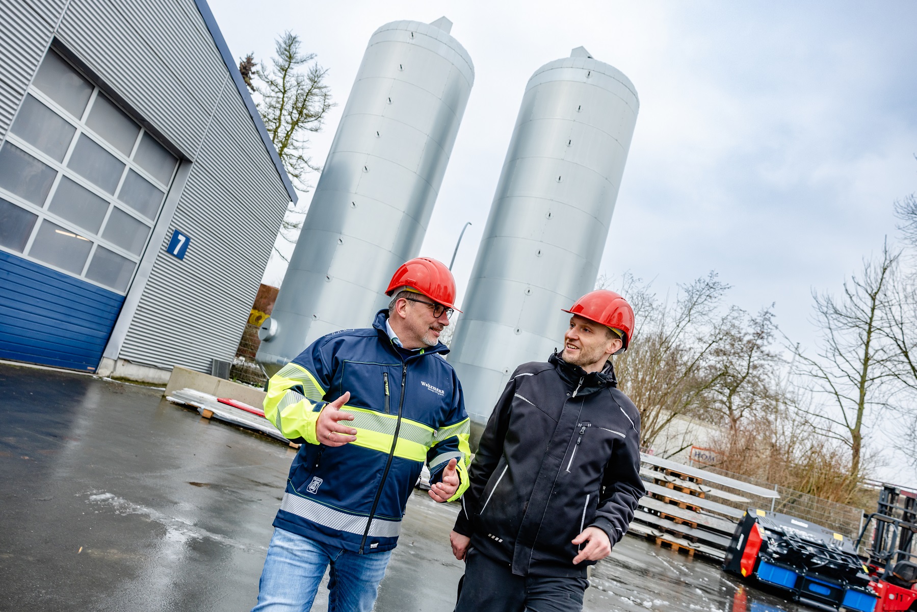 Frank Wehrmann (links) und Gebäudemanager Matthias Gering inspizieren die beiden Pufferspeicher. (Foto: Simone Reukauf) Frank Wehrmann (links) und Gebäudemanager Matthias Gering inspizieren die beiden Pufferspeicher. (Foto: Simone Reukauf)