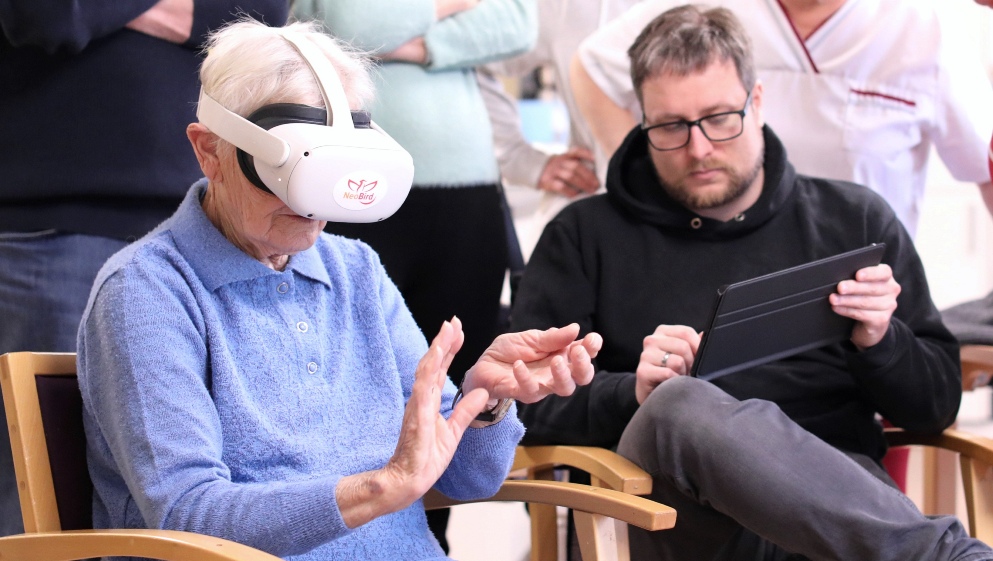 •	Seniorin erkundet mit einer VR-Brille verschiedene Spielstationen #JockiFoto