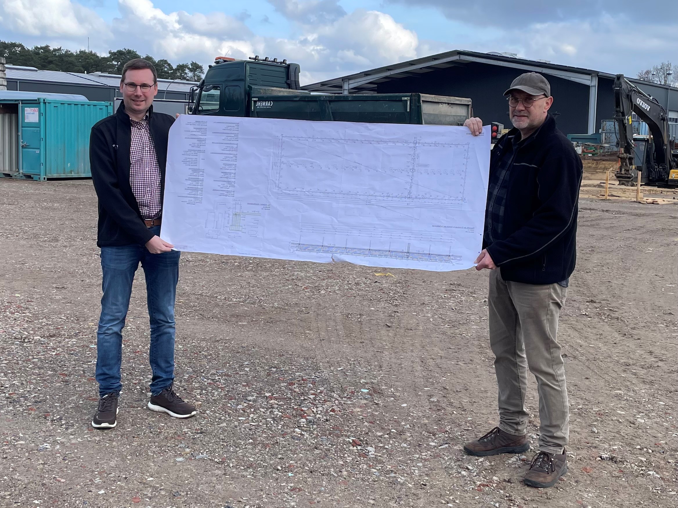Jannik Meese (links) und Wilhelm Meese (rechts) auf der Baustelle mit Hallenplan