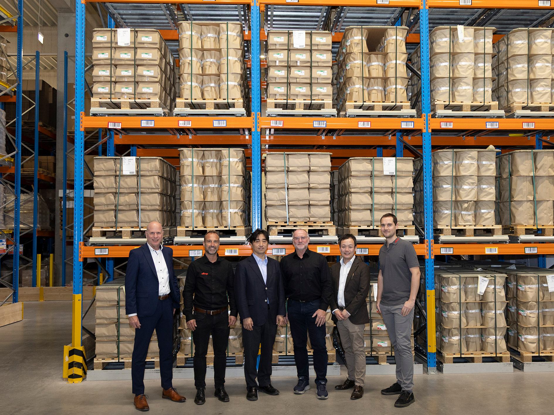 allcop und Fujifilm-Delegation vor dem Hochregallager mit Fujifilm-Fotopapieren (Bildquelle: Jan Keller)