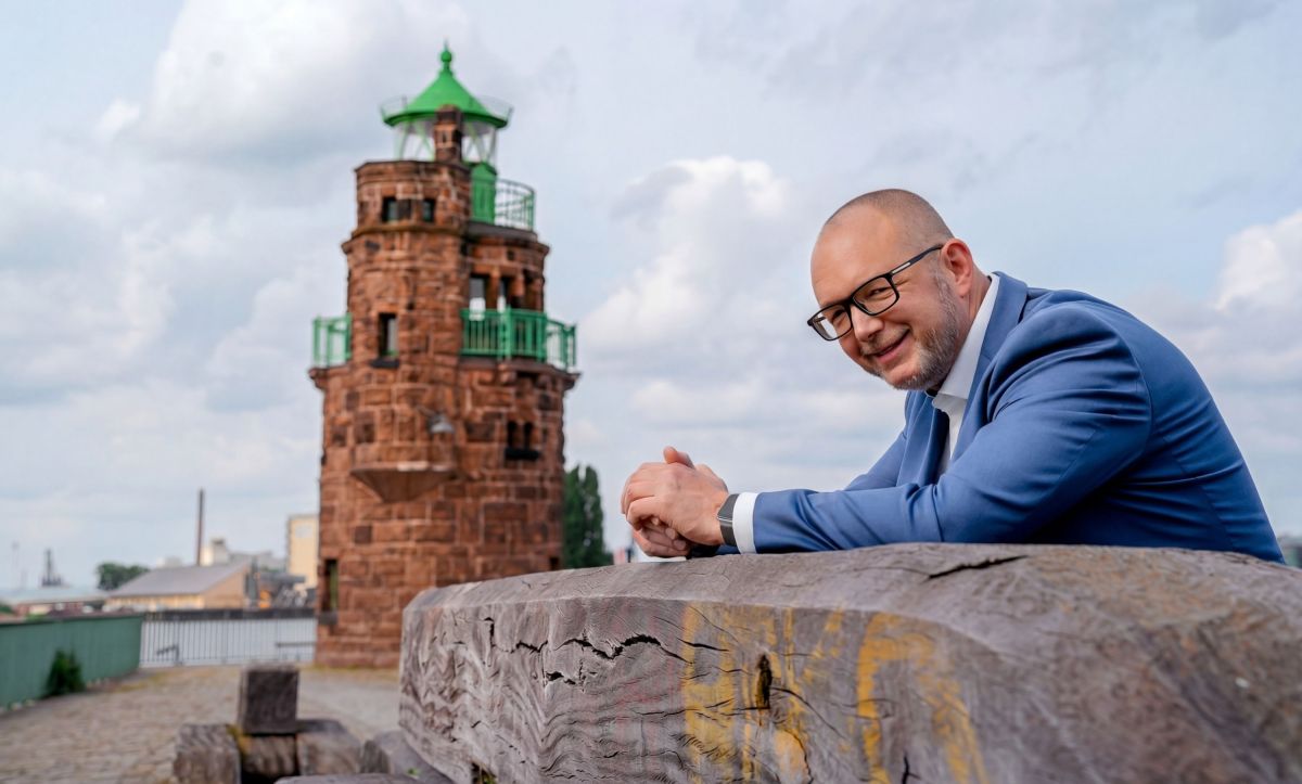 Marketingexperte Alexander Flögel vor Leuchtturm als Symbol für zu hebende Krisenpotenziale (© Mitja Rüdebusch)