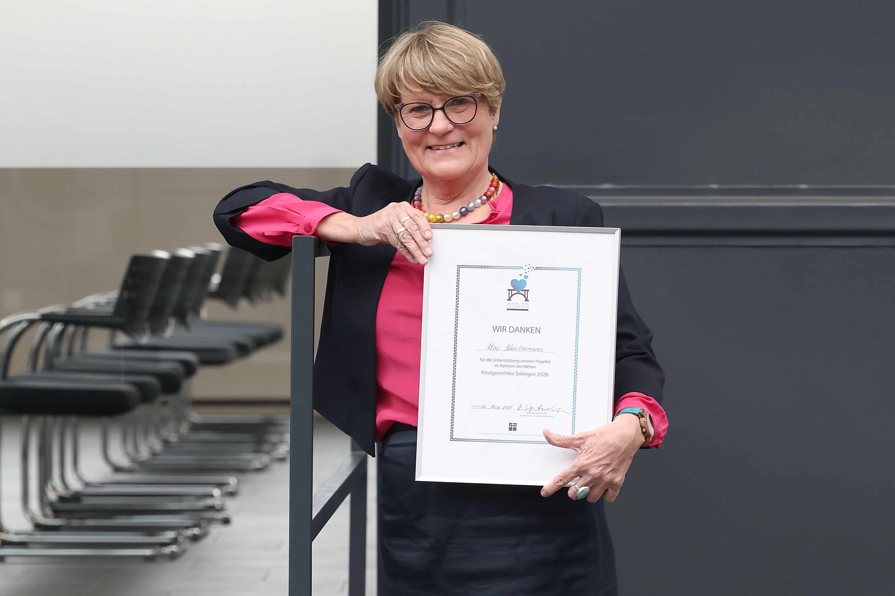 Ulrike Kilp, Geschäftsführerin des Diakonischen Werks, mit der neuen"Diakonie-Aktie Solingen" (Bildquelle: Diakonisches Werk Solingen/Christian Beier)