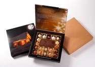 Pralinen und ein individuell geprägtes Schokologo in weihnachtlicher Geschenkbox. Foto: Schokologo