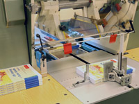 Mit dem Dreiseitenbeschnitt ist das Buch fertig und verlässt die Bindemaschine (Bild: Vögel). Mit dem Dreiseitenbeschnitt ist das Buch fertig und verlässt die Bindemaschine (Bild: Vögel).