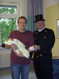 Schornsteinfeger Bernhard Zwirner überreicht Joela und Vater Jonathan Henschke einen Feuermelder
