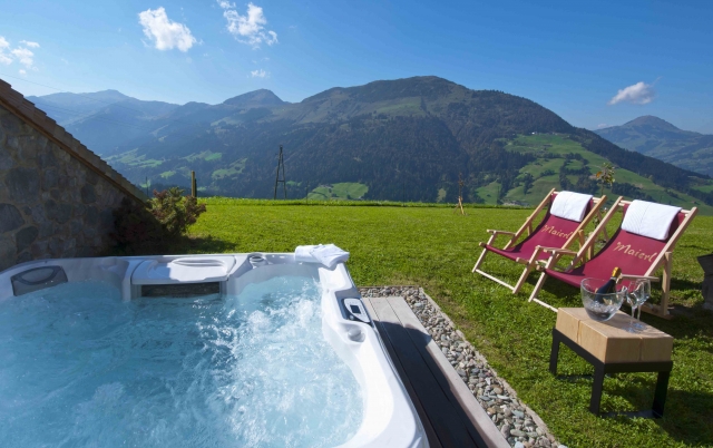 Während der Maierl-Familienwochen entspannen die Eltern im privaten Outdoor-Whirpool auf der Chalet-